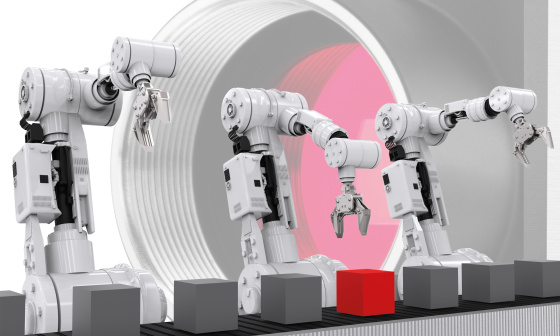カメラの前に立ち、ベルトコンベアからキューブをつかむロボットのイラスト。