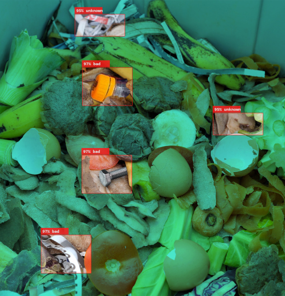 IDS 産業用カメラは、開いたゴミ収集容器に存在するプラスチックゴミを異物として認識し、有機廃棄物から区別します。
