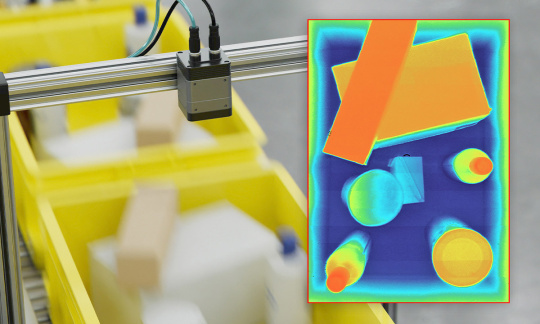 3Dカメラが、ベルトコンベア上の黄色いボックスに入った物体の深度画像を撮影。