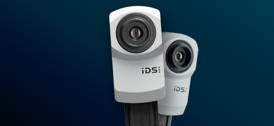 青い背景に設置された 2 台の IDS uEye XC 産業用カメラ。