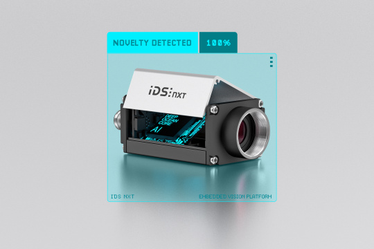 ネオンの文字で「AI」と表示されたオープンハウジングのIDS NXT。青いフレームに入ったカメラと「novelty detected 100%」の文字。