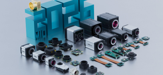 3Dの「2026」の数字、中央の「2」にゴールドのカメラ、その前にIDSカメラ製品群が長方形に並ぶ