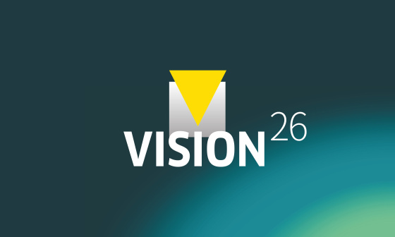 青緑色の背景に「VISION26」の文字が入ったグラフィック。