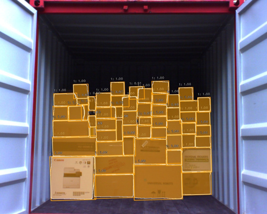 様々な荷物が積み重ねられた荷積みエリアとそのスケール