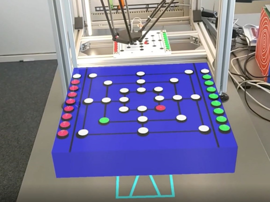 ロボットは箱の中でミルをプレイし、箱の前にはロボットと対戦するためのゲーム盤がある。