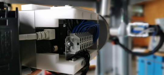 IDS の GigE Vision カメラと、ロボットアームに取り付けられた照明で構成されるセットアップ